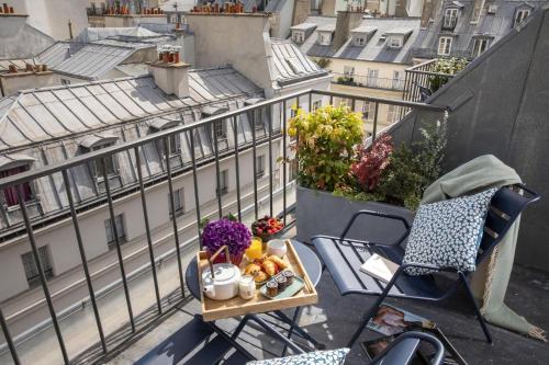 una bandeja de comida en una mesa en un balcón en Les Matins de Paris & Spa, en París