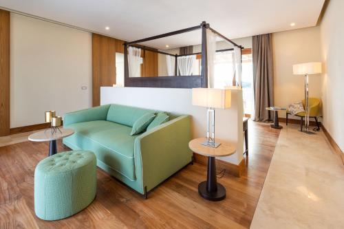 a living room with a green couch and a mirror at Il San Corrado di Noto in Noto