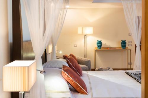 a hotel room with a bed with pillows at Il San Corrado di Noto in Noto