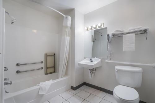 a white bathroom with a toilet and a sink at Americas Best Value Inn Green River in Green River