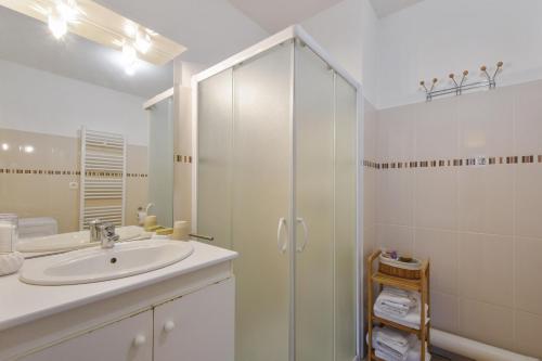 uma casa de banho branca com um lavatório e um chuveiro em Jasmin em Rouen