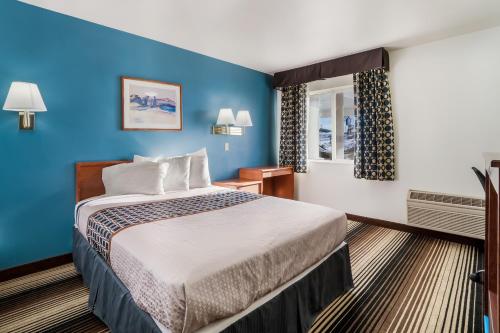 Habitación de hotel con cama y pared azul en Americas Best Value Inn Green River, en Green River