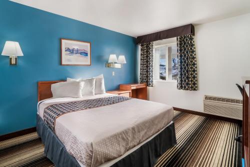 una camera d'albergo con letto e parete blu di Americas Best Value Inn Green River a Green River