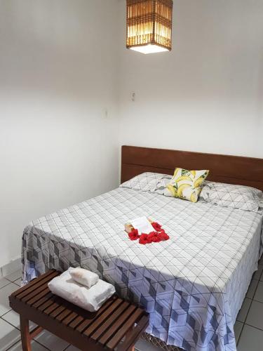 a bed with two towels and a wooden bench at Pousada Porto de Paz - Noronha in Fernando de Noronha