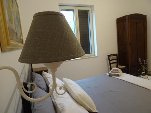 a lamp sitting next to a bed in a bedroom at Masseria Scianne in Sant'Isidoro