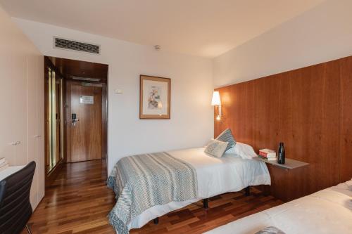 Habitación de hotel con cama y TV en Micampus Pamplona en Pamplona