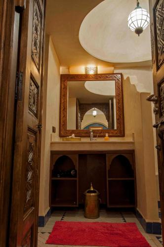 a bathroom with a sink and a mirror at Riad Merzouga in Marrakech