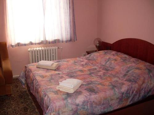 1 dormitorio con 1 cama con toallas en Horska Chata Nejdecka, en Pernink