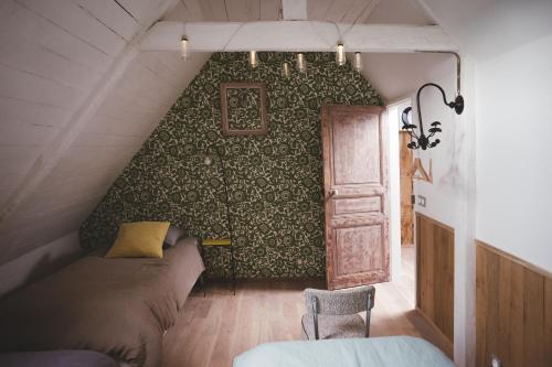 1 dormitorio con cama y pared verde en Chambres d'hôtes de charme - Gîtes cosy - LA CLE DES CHAMPS - A la campagne, en Martigné-Ferchaud