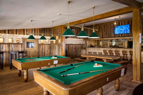 a billiard room with two pool tables and a tv at Pullman City Westernstadt in Eging