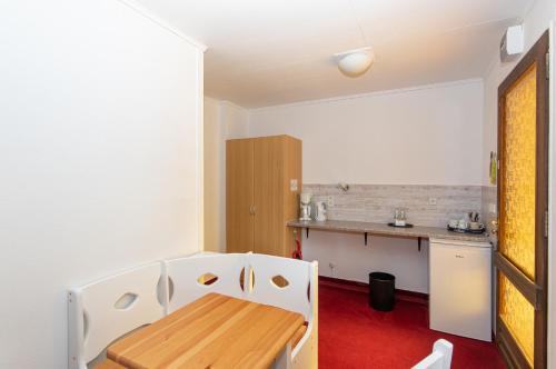 a kitchen with a wooden table and white chairs at Spreewaldhotel Garni Raddusch in Vetschau