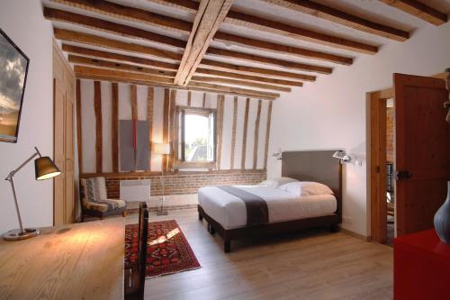 a bedroom with a bed and a chair in a room at Le Jardin Découverte in Conches-en-Ouche