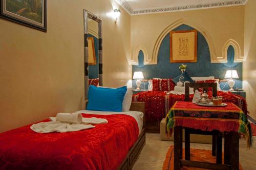 a bedroom with two beds with red and blue at Riad Merzouga in Marrakech