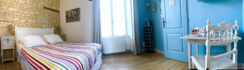 a bedroom with blue walls and a bed with a colorful blanket at Ecole de Mathuna de Marigny Brizay in Marigny-Brizay