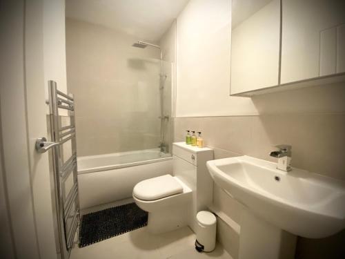 een witte badkamer met een toilet en een wastafel bij Bronte Nook, Haworth Village, Bronte Country in Haworth