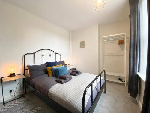 1 dormitorio con 1 cama con almohadas azules y amarillas en Bronte Nook, Haworth Village, Bronte Country, en Haworth