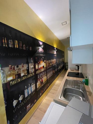 a kitchen with a shelf with bottles of alcohol on the wall at Joanna Apartment - MA Rheinau in Mannheim