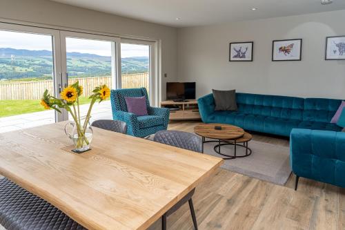 a living room with a table and a couch at The Annexe, Luxury Property with Hot Tub at Pitilie Pods in Aberfeldy