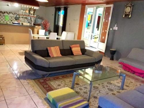 a living room with a couch and a glass table at Villa de 4 chambres avec piscine partagee terrasse amenagee et wifi a Le Tampon in Le Tampon