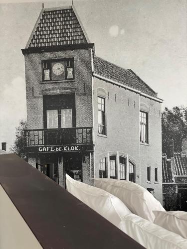 a black and white photo of a building with a clock tower at Boutique hotel Hippe Hendrik in Hendrik-Ido-Ambacht