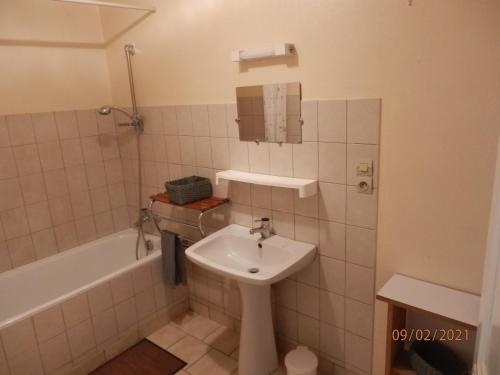 a bathroom with a sink and a bath tub and a sink at GITE LES MYOSOTIS in Le Chambon-sur-Lignon