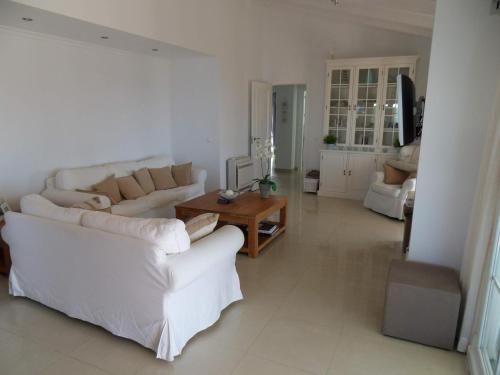 a living room with two white couches and a table at Villa Perla Blanca in Sayalonga