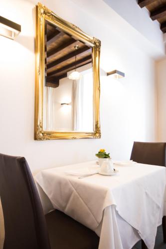 un tavolo con una tovaglia bianca e uno specchio di Hotel Bryghia a Bruges