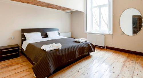 1 dormitorio con 1 cama grande y espejo en lovely Dulcet Loft In Center Of Rustaveli, en Tiflis