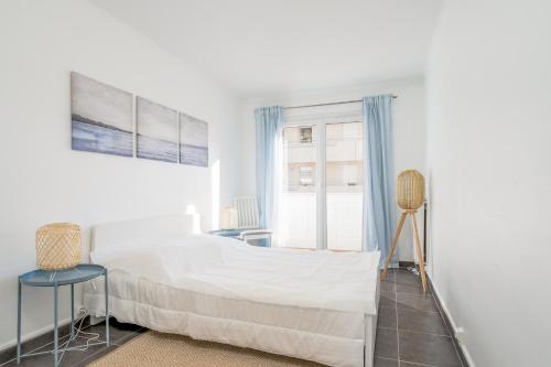 une chambre blanche avec un lit et une fenêtre dans l'établissement Appartement Corail - Welkeys, à Antibes