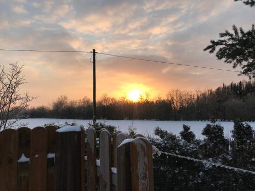 a fence in front of a snowy field with the sunset at Kleine Auszeit mit Aussicht Velbert Tönisheide in Velbert