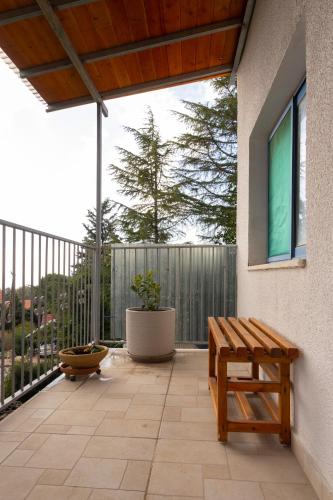 a patio with a wooden bench on a balcony at House On The Mountain in Neve Ativ