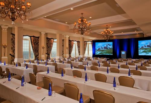 a conference room with white tables and chairs and a large screen at The Don CeSar in St Pete Beach