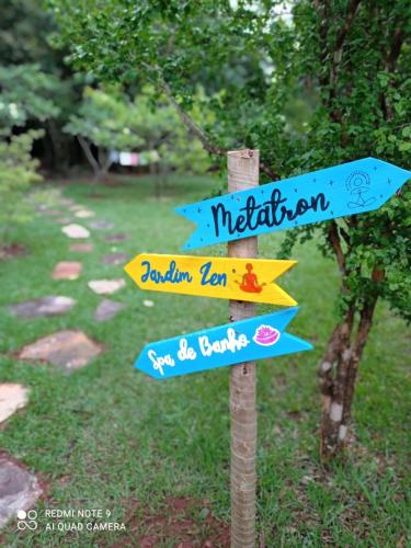 a street sign with arrows pointing in different directions at Pousada Alfa e Ômega in Alto Paraíso de Goiás