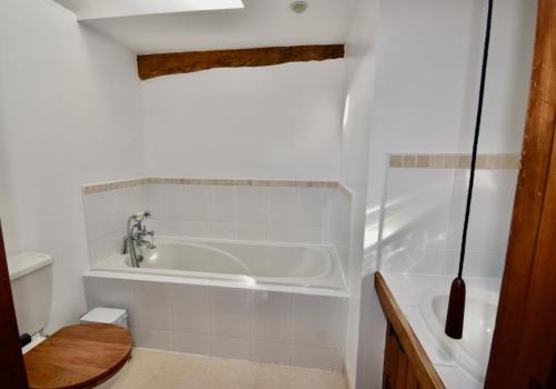 a white bathroom with a tub and a toilet at The Cote is a stunning rural barn beach 3 miles in Ryde