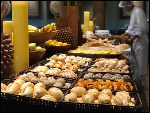 een buffet gevuld met veel verschillende soorten gebak bij Polinésia Resort Beira Mar Muro Alto Porto de Galinhas in Porto De Galinhas