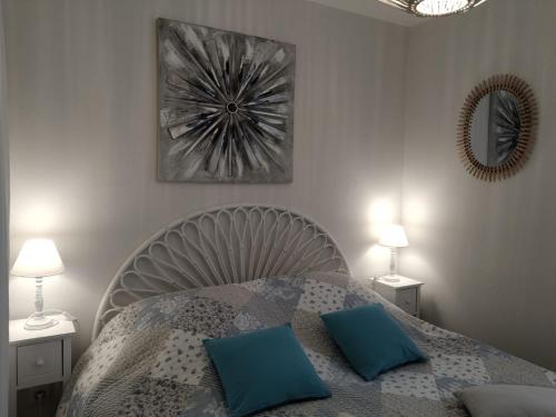 une chambre avec un lit avec des oreillers bleus et un miroir dans l'établissement FLOTS DE L ISLE, à LʼIsle-sur-la-Sorgue