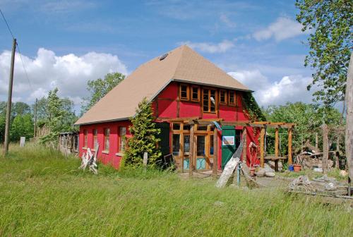 a red barn sitting in a field next to a field at Ferienwohnung Karow in Karow