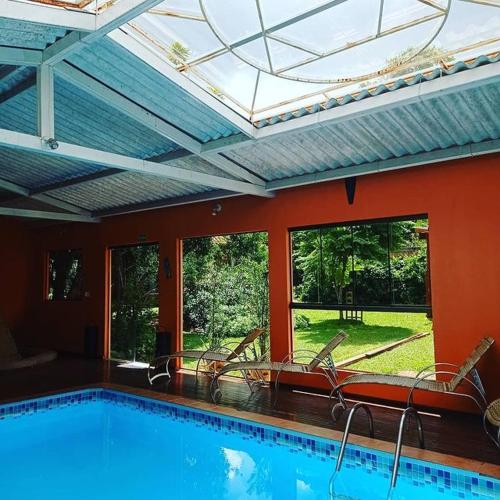 a large swimming pool with chairs in a house at Pousada Alfa e Ômega in Alto Paraíso de Goiás
