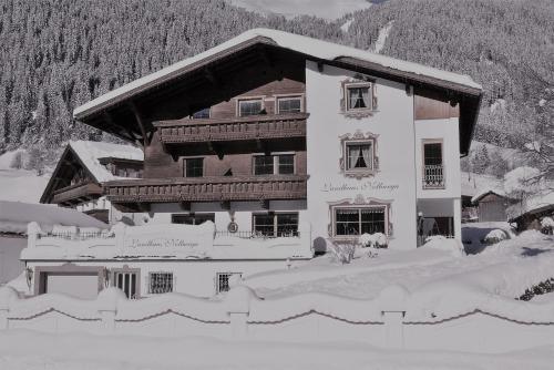 a large building covered in snow in front of a mountain at Landhaus Notburga in Gries im Sellrain