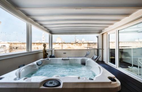 a bath tub in a room with a large window at B&B Palazzo San Michele in Bari