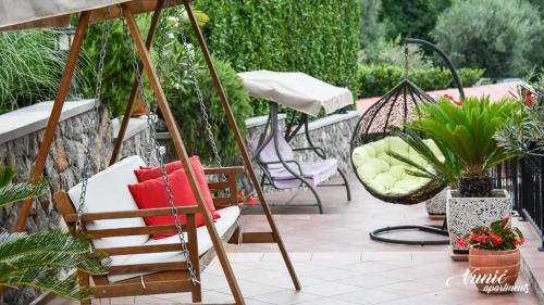 a group of chairs and an umbrella on a patio at Apartments Vunić in Mošćenička Draga