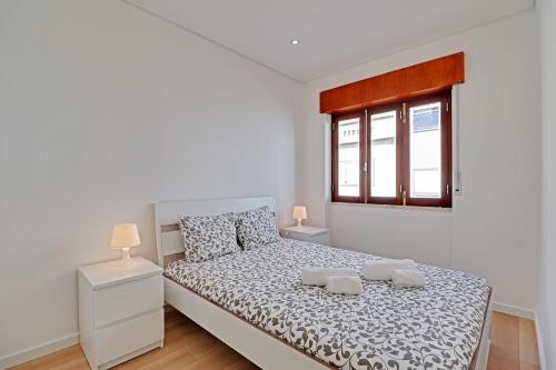 um quarto branco com uma cama e uma janela em The Fig and Almond Houses em Vila Real de Santo António