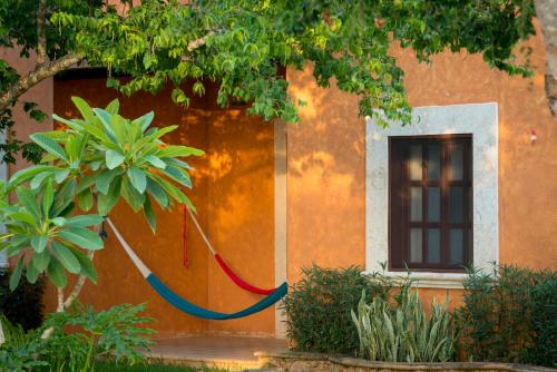 a red hose hanging from the side of a building at Hacienda Santa Cruz Merida in Mérida