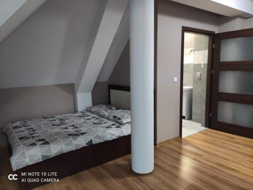 a bedroom with a bed and a white column at Noclegi Damianek in Nowy Targ