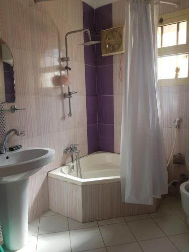 a bathroom with a bath tub and a sink at Elite Homes 3BR Sunny Apartment Families Only in 6th Of October