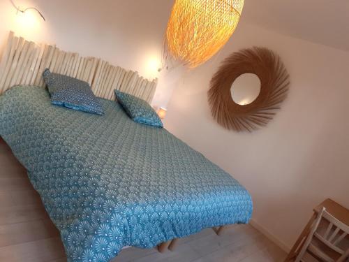1 dormitorio con 1 cama con sábanas azules y espejo en Au gîte des Mazes, en Ban-sur-Meurthe-Clefcy