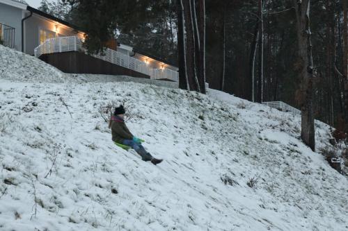 a person is standing on a snow covered hill at Przystań na Zagórzu - Apartamenty nad jeziorem in Drezdenko