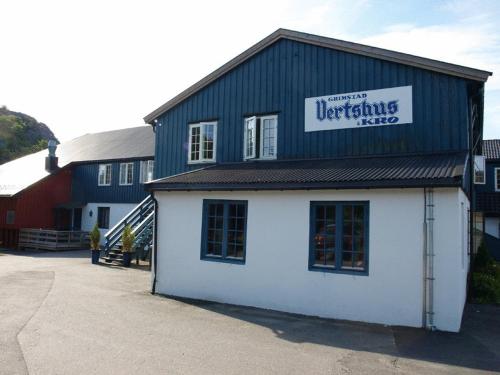 a white building with a sign on top of it at Grimstad Vertshus in Grimstad