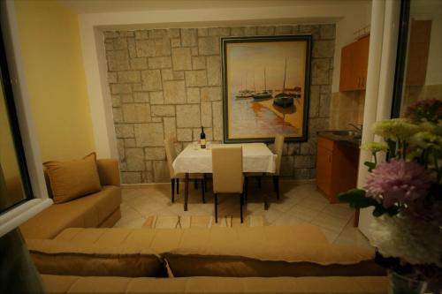 a living room with a table and a couch at Apartments Mitrovići Miločer in Sveti Stefan
