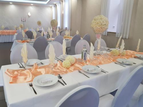 a long table with chairs and plates and flowers on it at Eventhaus Schamin in Erpen